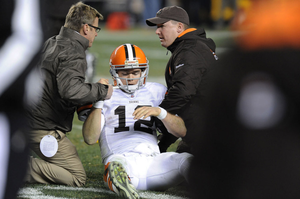 Trainers tend to Cleveland Browns quarterback Colt McCoy (12) after he was hit by Pittsburgh Steelers outside linebacker James Harrison in the fourth quarter of an NFL football game in Pittsburgh on Dec. 8, 2011.&#xA0;(AP Photo/Don Wright)