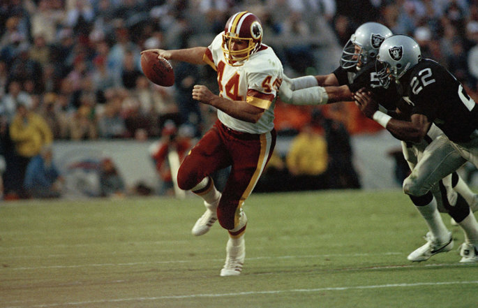 Former Washington running back Johns Riggins runs with the football.