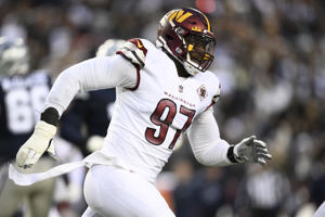 Washington Commanders player Efe Obada running during a football game.